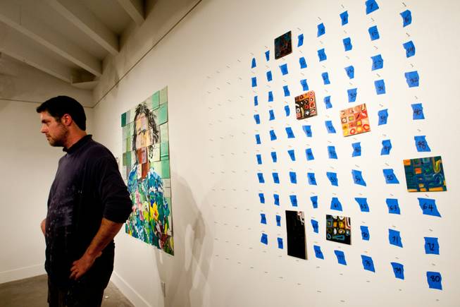 Artist Jason Adkins watches guests create individually painted squares to be used to create another iconic image of art to be displayed in P3Studio during his in-house residency at The Cosmopolitan of Las Vegas Friday, January 11, 2013. Featured on the left is a mug shot of Nick Nolte previously created by studio participants.